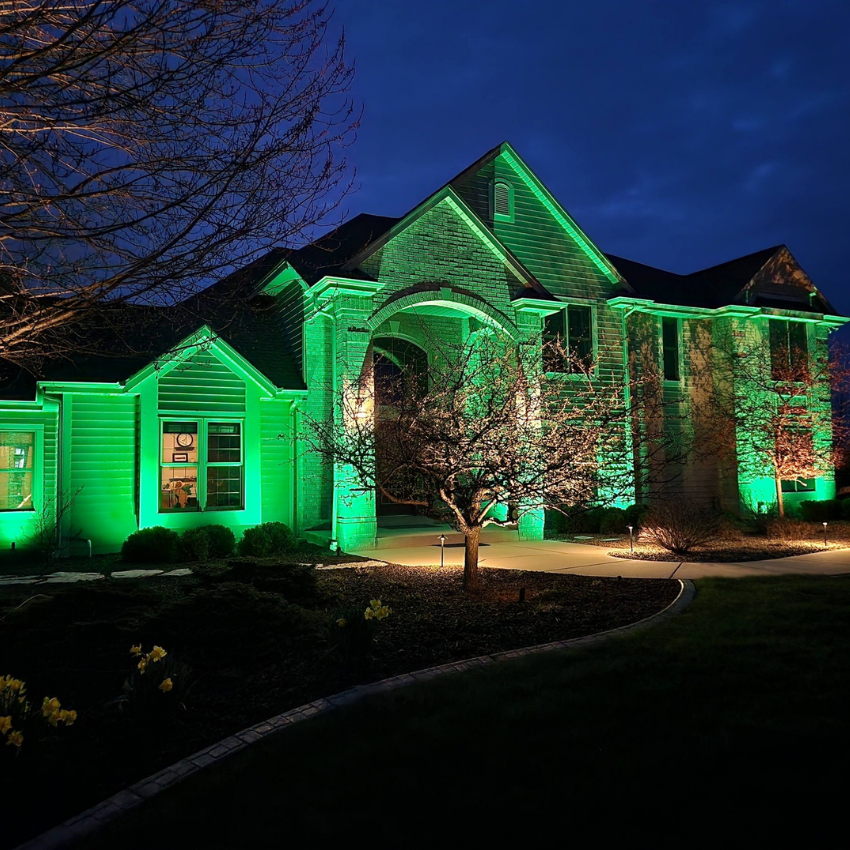 Color-changing RGB outdoor lighting highlighting a home with customizable landscape lighting at night Color-changing RGB outdoor lighting highlighting a home with customizable landscape lighting at night